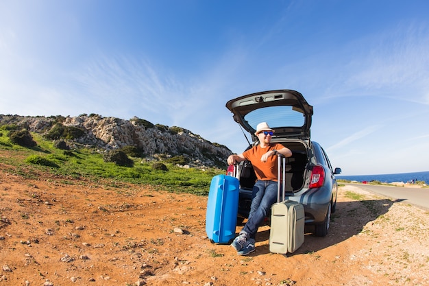 Homme heureux drôle partant en vacances d'été. Concept de voyage en voiture.