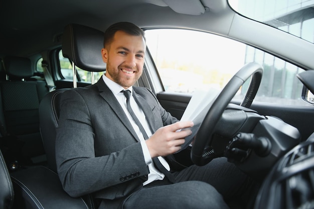 Homme heureux élégant attrayant dans une bonne voiture