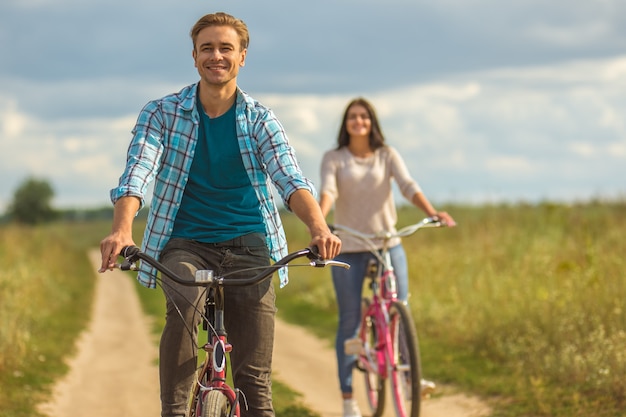 L'homme heureux faisant du vélo près de la femme en plein air