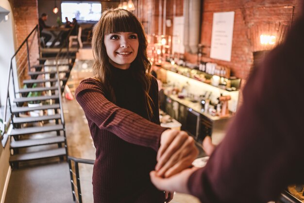 L'homme heureux et une femme se tiennent la main dans le restaurant