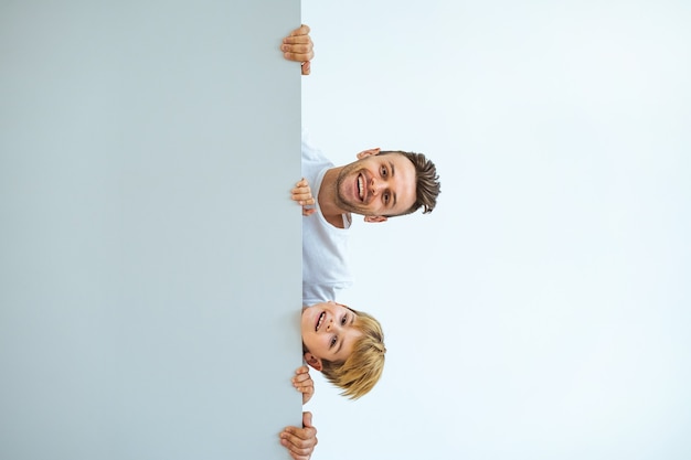 L'homme heureux et un garçon debout derrière le mur