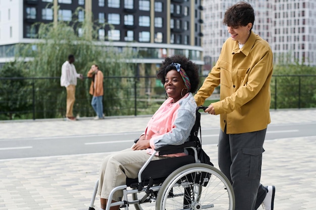 Homme heureux marchant avec sa petite amie handicapée dans la ville