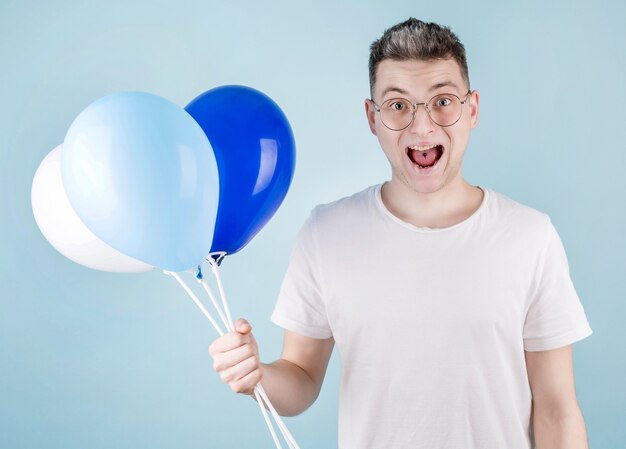 Un Homme Heureux Porte Des Ballons Colorés, Porte Des Lunettes. Un étudiant Joyeux Vient à La Fête Sortante