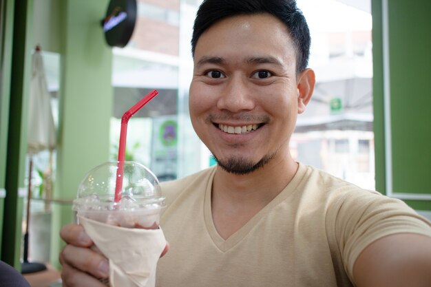 Homme heureux se selfie dans le café.