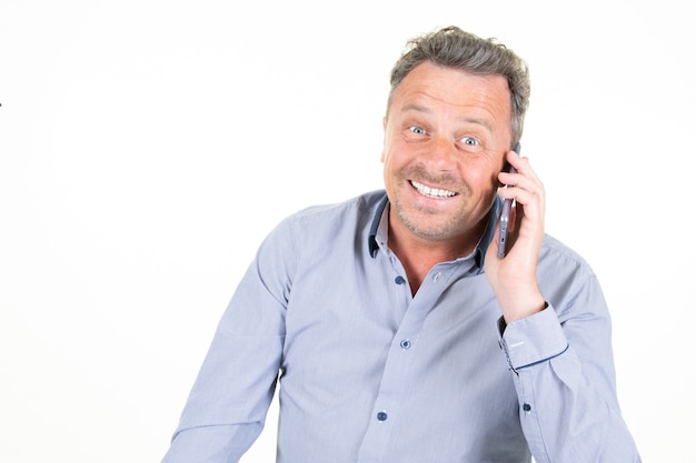 Homme heureux souriant parlant sur téléphone mobile smartphone isolé sur fond blanc