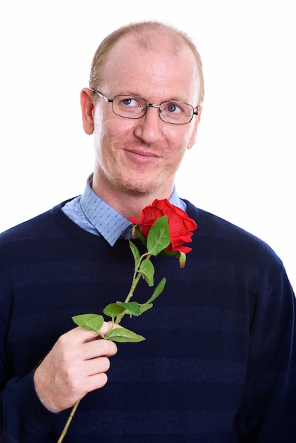 homme heureux souriant tout en tenant une rose rouge et pensant prêt pour la Saint-Valentin