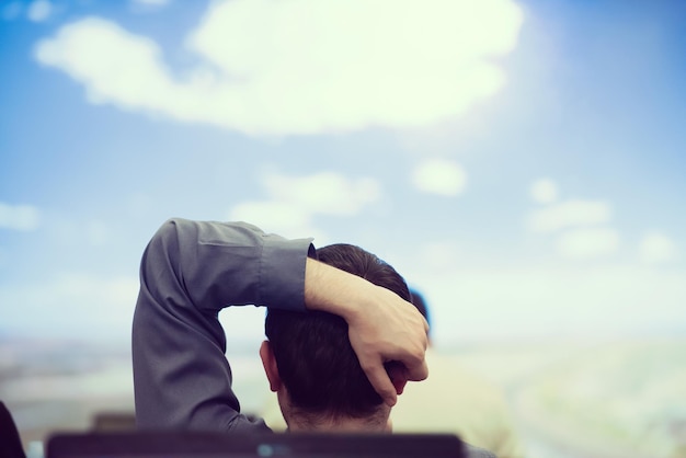 homme heureux en tant qu'audience assise et relaxante sur la présentation tout en regardant un beau ciel avec des nuages et rêvant