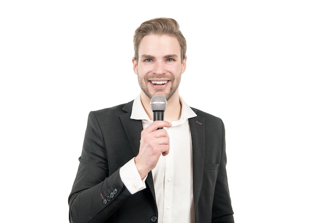 Un homme heureux en tenue de soirée parle dans un microphone donnant un discours isolé sur un conférence blanc