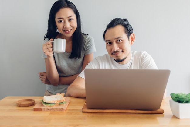 Un homme heureux travaille en ligne avec le soutien de sa femme dans le concept de travail à domicile.