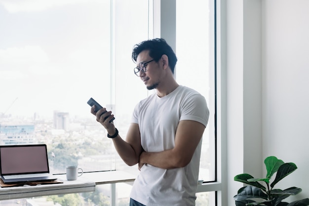 Un Homme Heureux Utilisant Un Smartphone Avec Un Concept De Vue Sur Le Balcon Travaille à Domicile