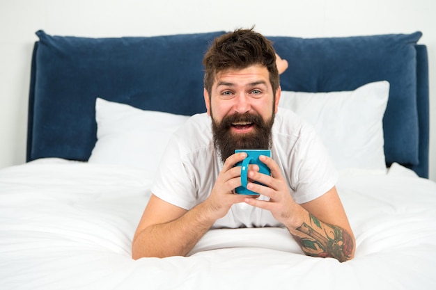 Homme heureux visage barbu boire le café du matin se détendre dans la chambre, concept de boisson aromatique.