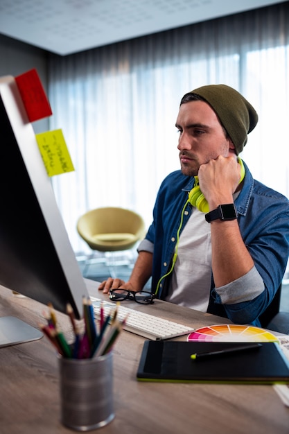 Homme hipster concentré travaillant avec un casque audio