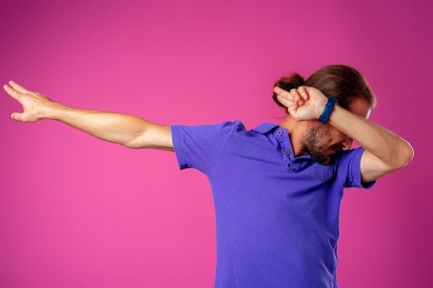 Homme de hipster en dab dance pose sur fond rose close up