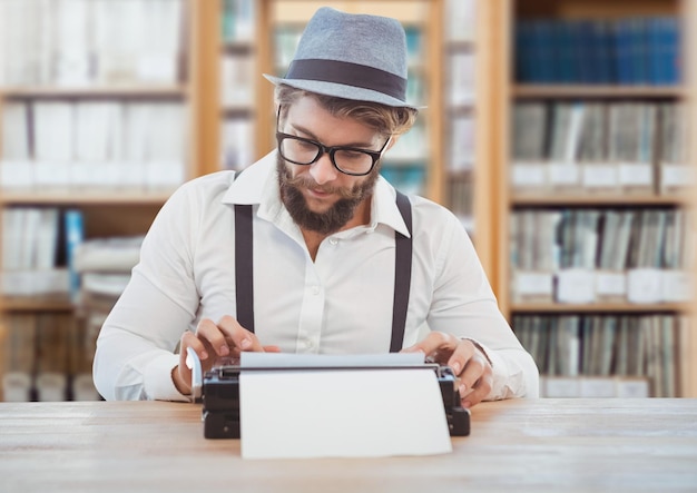 Homme hipster sur machine à écrire dans la bibliothèque