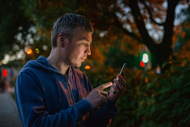 Homme de hipster parlant sur un téléphone portable la nuit en ville