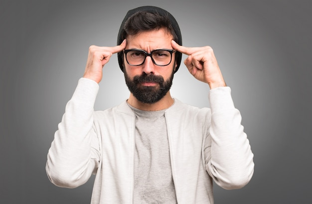 Homme de hipster pensant sur fond gris