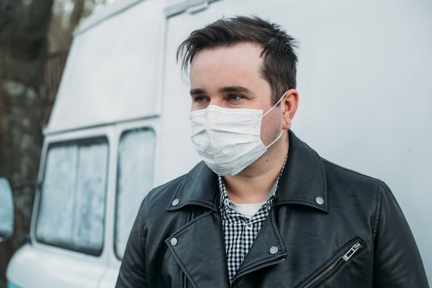 Homme hipster portant un masque de protection sur van rétro