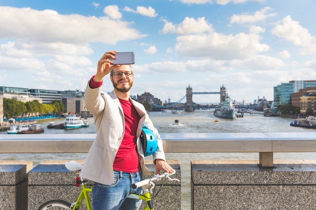 Homme hipster prenant un selfie à Londres lors de ses trajets
