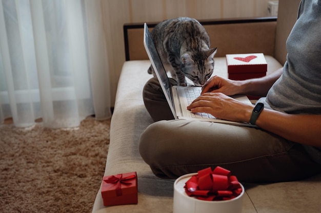 Un homme hipster avec une tasse rouge assis à la maison au moment de Noël