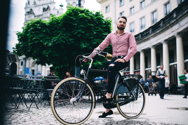 Homme hipster à vélo dans la rue