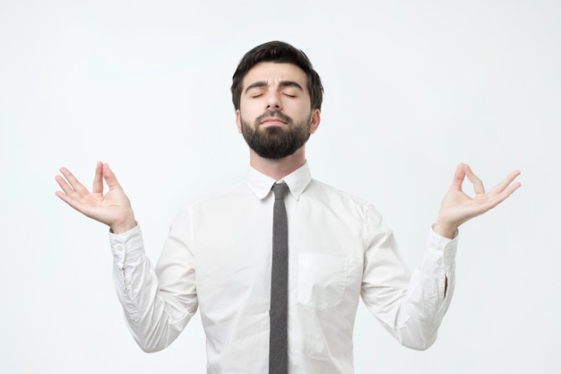 Un homme hispanique barbu concentré qui médite essaie de se détendre après une dure journée de travail