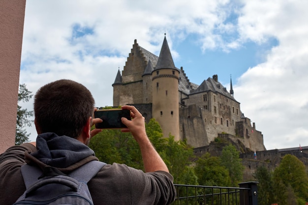 Un homme hispanique prenant des photos du château de Vianden au Luxembourg