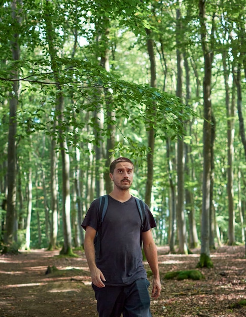 Un homme hispanique avec un sac à dos marchant dans la forêt