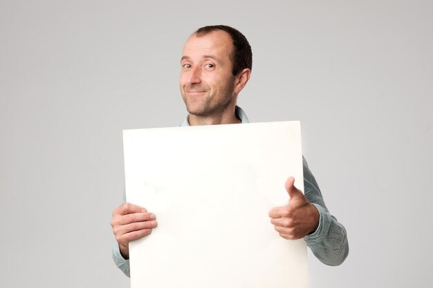 L'homme hispanique tient le signe vierge dans un studio fond blanc