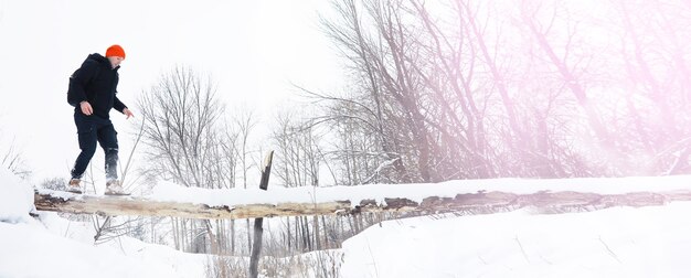 Un homme en hiver dans la forêt. Un touriste avec un sac à dos traverse les bois en hiver. Ascension hivernale.