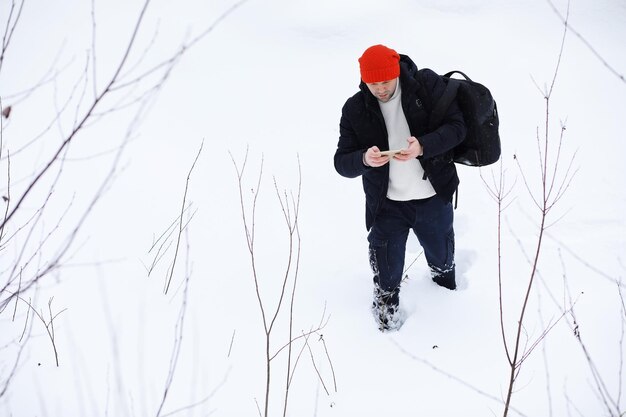 Un homme en hiver dans la forêt. Un touriste avec un sac à dos traverse les bois en hiver. Ascension hivernale.