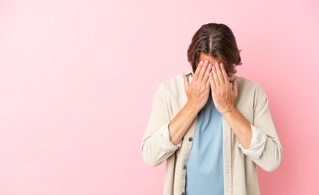 Homme hollandais senior isolé sur fond rose avec une expression fatiguée et malade