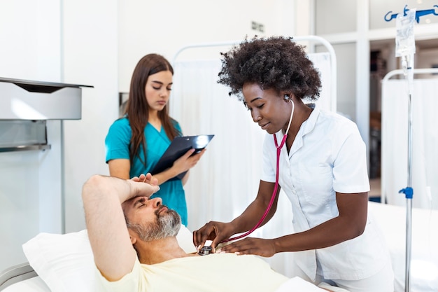 Homme hospitalisé couché dans son lit pendant que le médecin vérifie son pouls