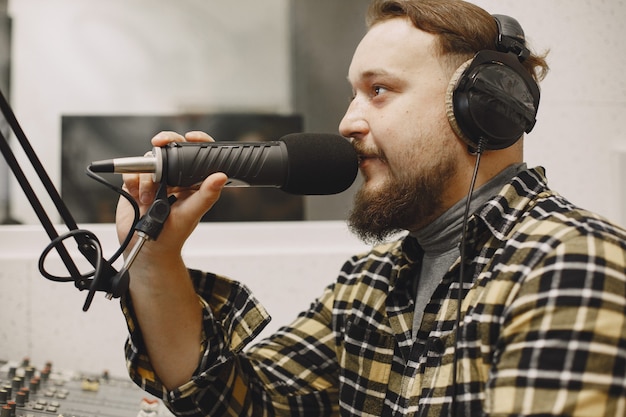 Homme hôte communiquant sur microphone. Homme en studio radio.