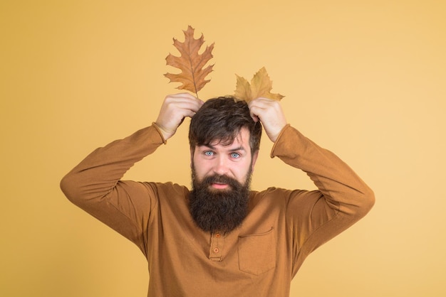 Homme d'humeur automnale avec des feuilles d'automne jaunes dans des vêtements d'automne à la main pour la mode d'automne saisonnière pour homme