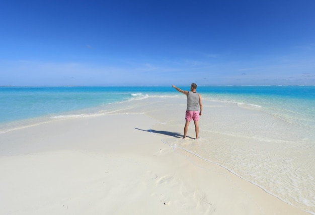 un homme sur une île tropicale avec du sable blanc dans l'océan