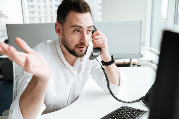 Photo homme incompréhensible parlant au téléphone