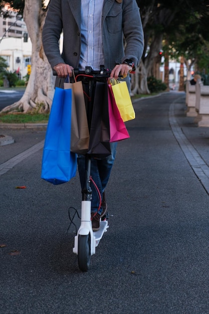 Homme inconnu avec des sacs en papier recyclables dans un véhicule électrique