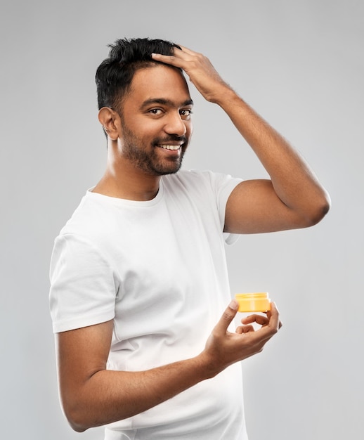 homme indien appliquant de la cire pour les cheveux ou du gel de coiffure