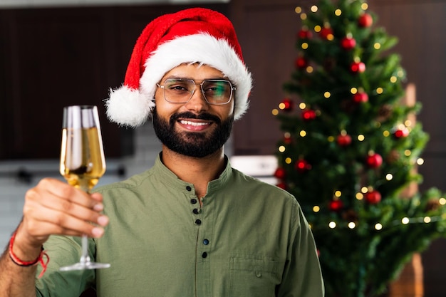 Homme indien buvant de l'alcool à la maison fond de guirlande de lumières de sapin de Noël