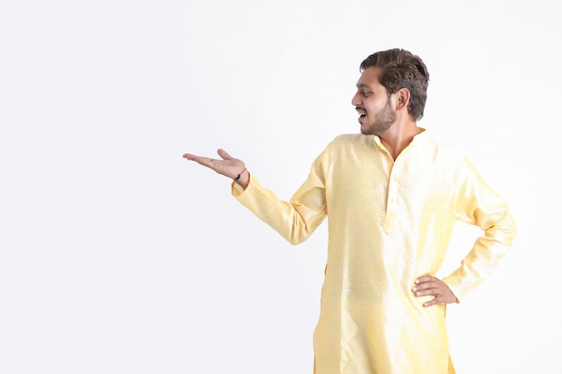 L'homme indien dans l'usure de la tradition et montrant une expression excitée sur un mur blanc
