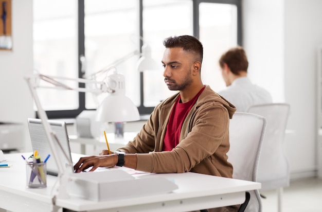 un homme indien avec un ordinateur portable au bureau