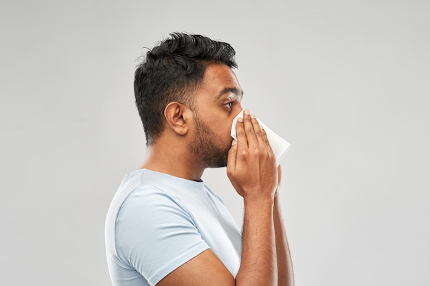 homme indien avec une serviette en papier soufflant le nez