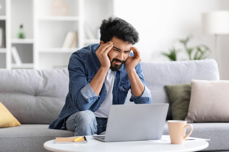 Photo un homme indien stressé qui a mal à la tête en travaillant sur un ordinateur portable à la maison