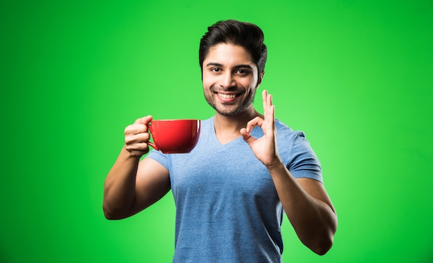 Homme indien avec une tasse ou une tasse de thé ou de café. Boire, présenter ou tenir en position isolée