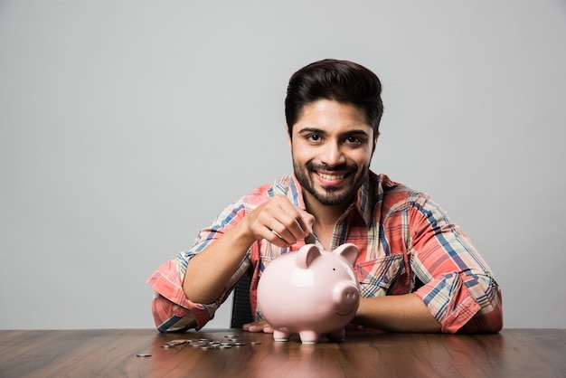 L'homme indien avec tirelire, assis à table