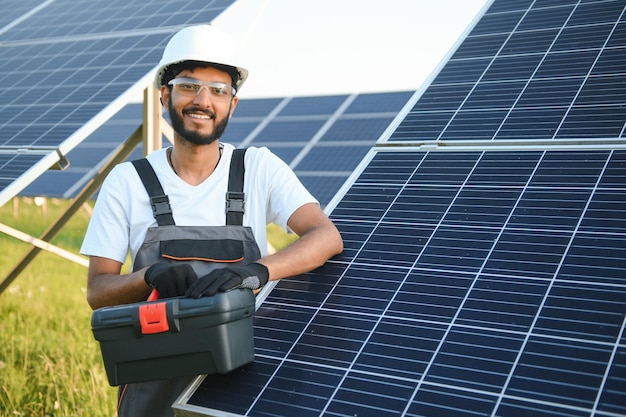 Un homme indien en uniforme travaillant près d'un panneau solaire