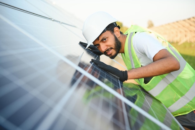 Un homme indien en uniforme travaillant près d'un panneau solaire