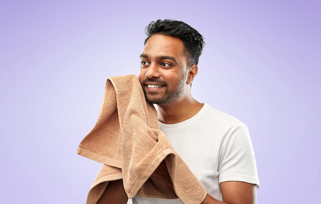 Photo homme indien utilisant une serviette de bain sur fond violet