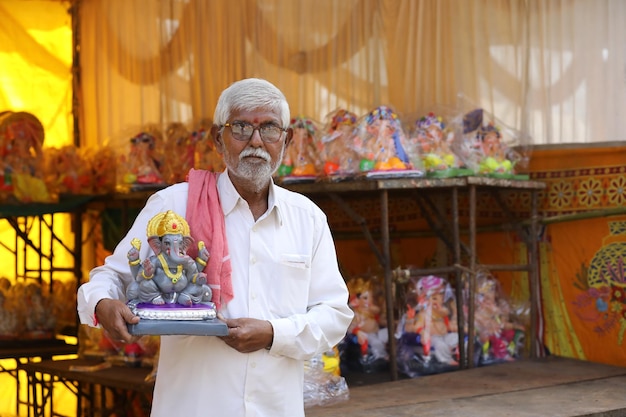 Homme indien vendant la sculpture de ganesha