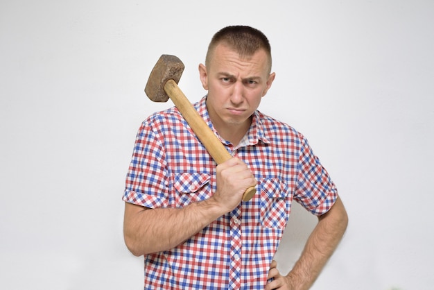 Homme indigné avec un marteau sur un blanc. Travail